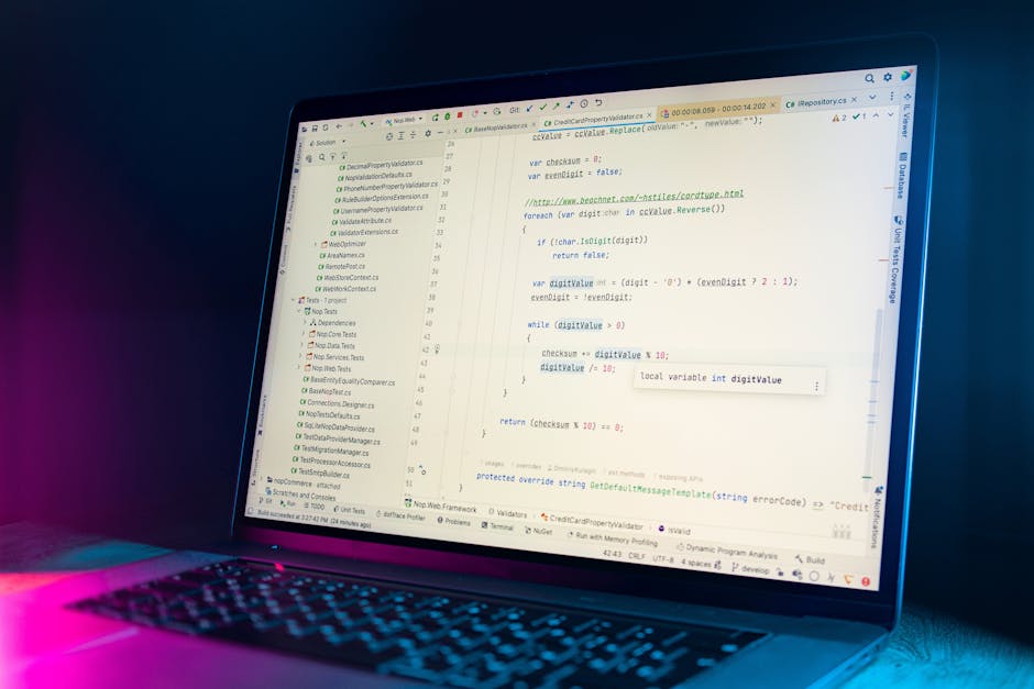 A close-up of a laptop displaying a code editing software with lines of programming code on the screen. The screen shows a text editor with syntax highlighting, line numbers, and various open tabs and